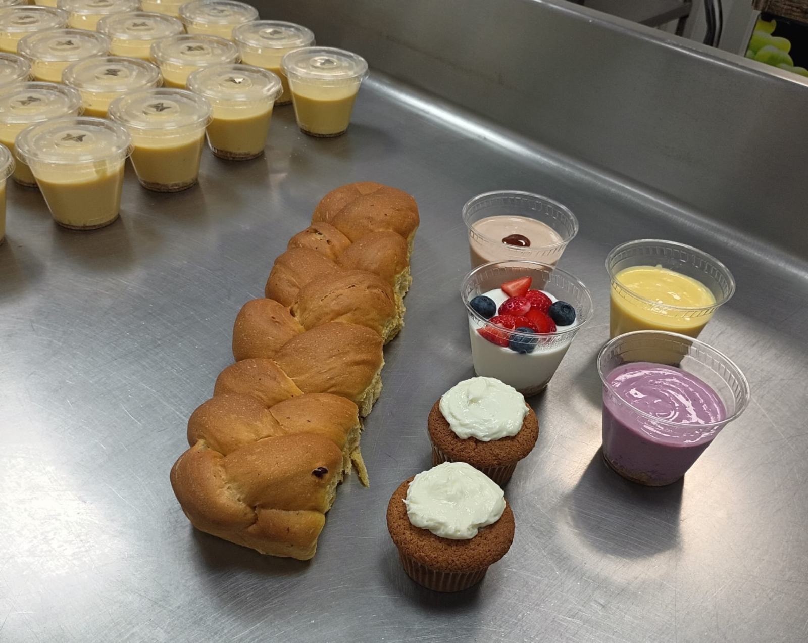 Trenza de Pan Manolo, cupcakes de zanahoria con queso crema y yogures artesanales sobre la mesa del taller