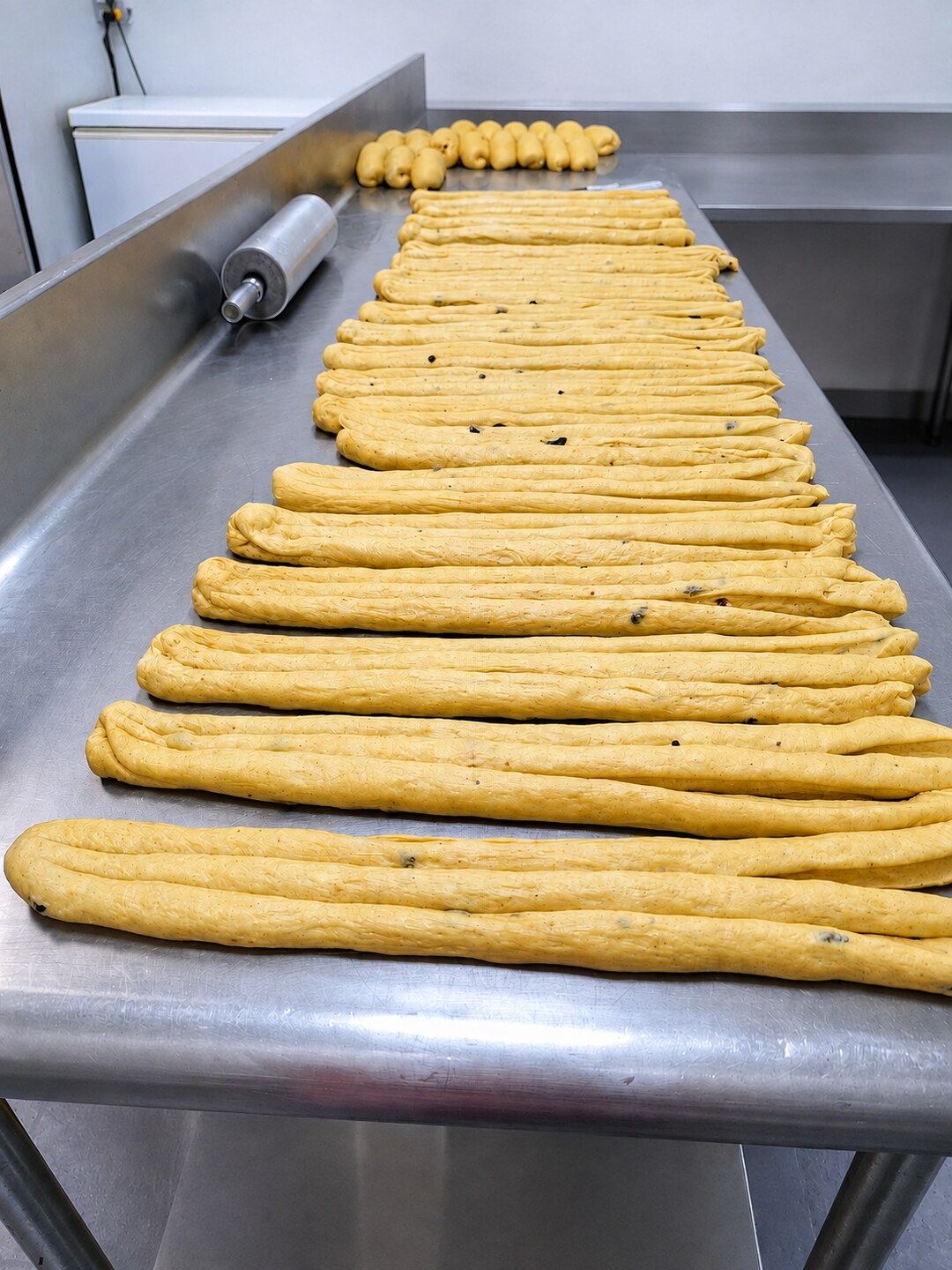 Tiras de masa de Pan de Calabaza sobre la mesa de acero del taller